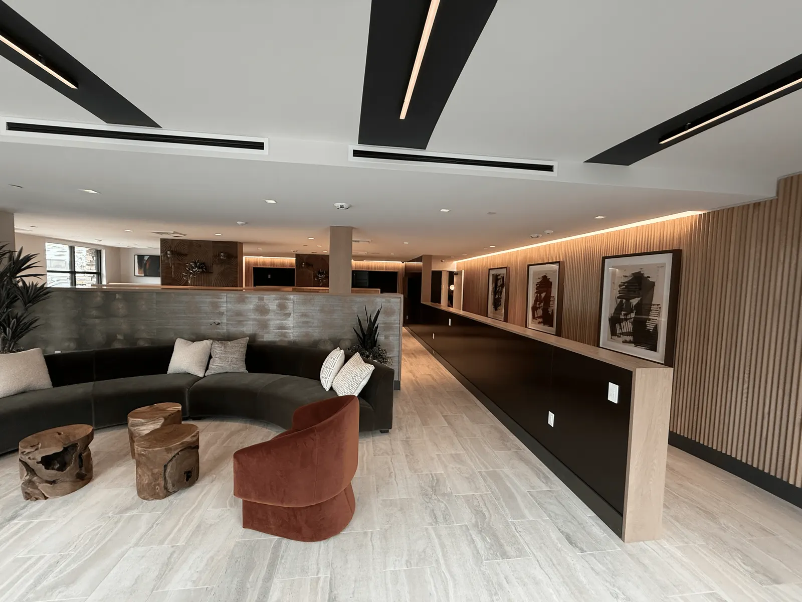 Lobby at Marlowe Sand Canyon with full-height wood slat wall paneling and a long wood-capped divider wall