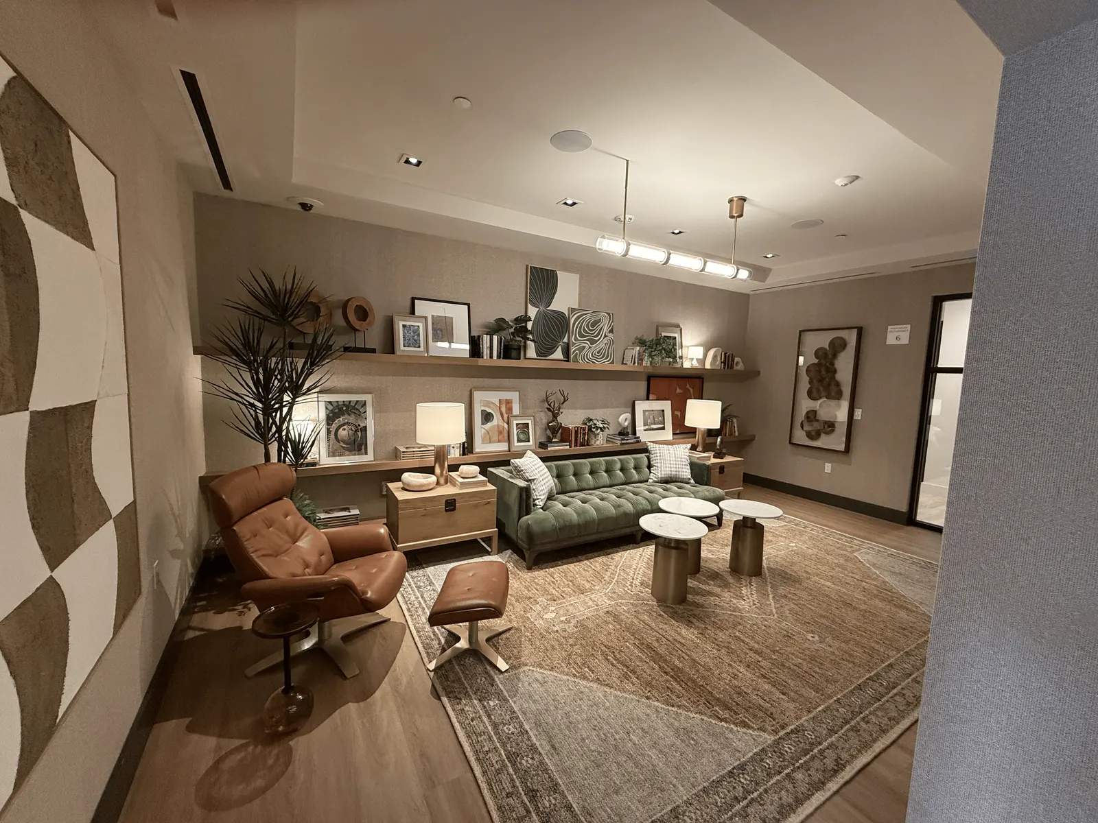Clubroom media wall of wood paneling with lit vertical reveals above a long floating console