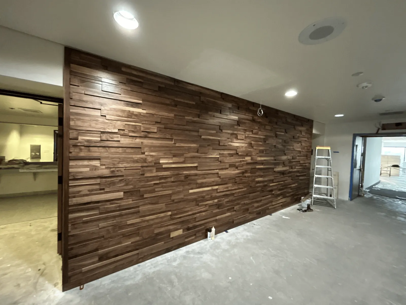 Ledge-pattern wood wall beside an open doorway, with an unfinished floor visible