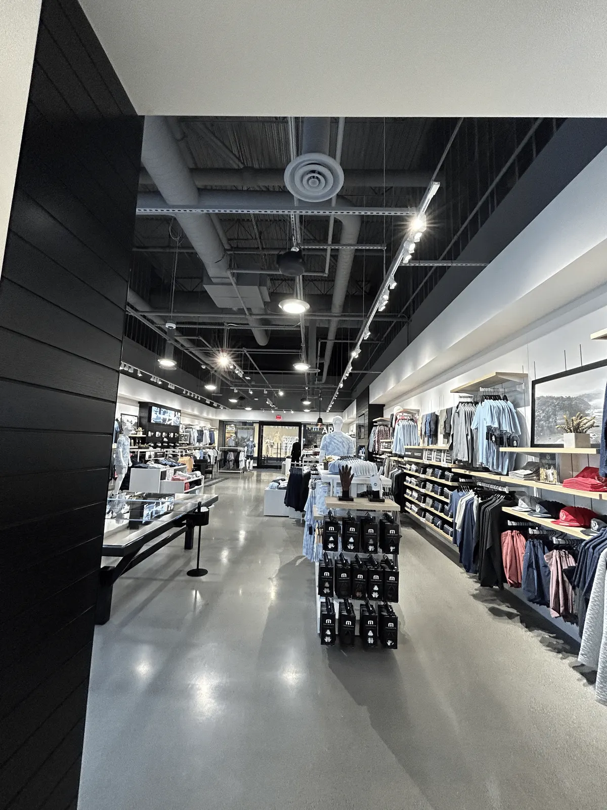 Black horizontal wood cladding at the TravisMathew store entry, looking past it onto the sales floor